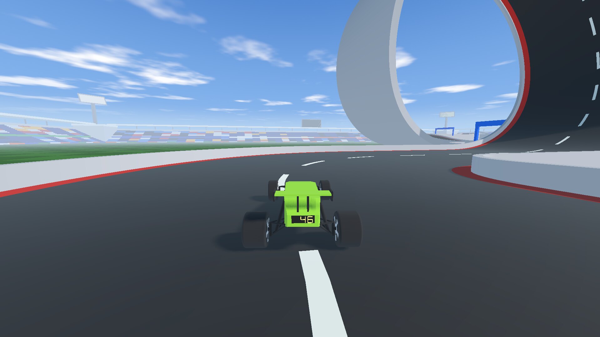 The car on the run-up to a loop, the stadium behind.